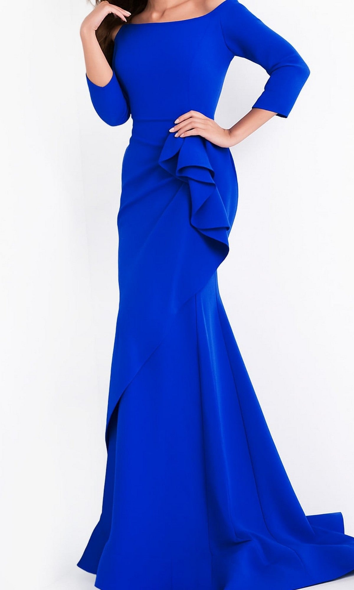 Model showcases the Jovani Mother-of-the-Bride Long Formal Dress 00446, a floor-length royal blue evening gown featuring three-quarter sleeves and a ruffled skirt detail, posing elegantly with one hand on her hip.